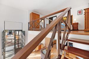 een trap in een woonkamer met houten vloeren en witte muren bij Finca Emblemática - Nº6 Timbayba in La Vegueta +15 foto's