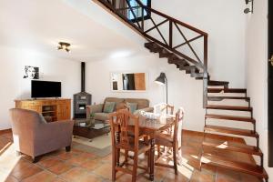 een woonkamer met een trap en een tafel bij Finca Emblemática - Nº6 Timbayba in La Vegueta
