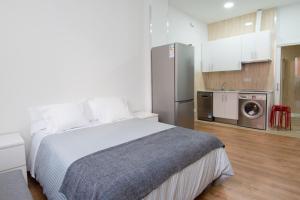 a bedroom with a bed and a kitchen with a refrigerator at Apartments Center Madrid in Madrid