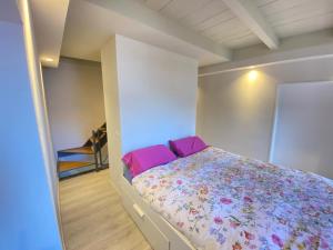 a bedroom with a bed with pink pillows at Casa Spasù in San Bartolomeo