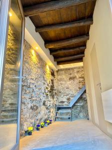 a room with a stone wall and a staircase at Casa Spasù in San Bartolomeo
