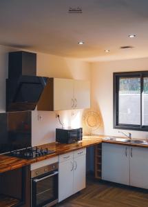 a kitchen with white cabinets and a wooden counter top at Villa la fournaise in Le Tampon