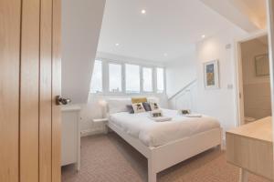 a bedroom with a white bed and a window at Stylish, family friendly central Windermere home with wood burner in Windermere