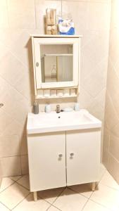 a bathroom with a white sink and a mirror at CASA NATALIA - Guesthouse in Luanda