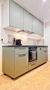 uma cozinha com electrodomésticos de aço inoxidável e um fogão em Maison Mayel - Logement Entier - Domaine Privé Résidentiel Chic & Nature em Lamorlaye