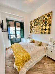 1 dormitorio con 1 cama grande con manta amarilla en Apartamento 4pax en pleno centro Alfalfa, en Sevilla