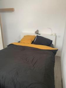 a bedroom with a bed with black sheets and pillows at Maison a étages bord de mer in Notre-Dame-de-Monts +7 photos