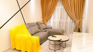 sala de estar con sofá y mesa en Kulai Apartment 5BR11Pax near IOI, Aeon and Senai Airport en Kulai