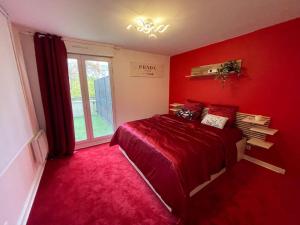 a red bedroom with a bed and a window at Spa House , love room in Tremblay En France
