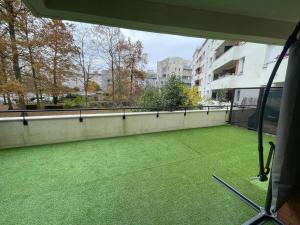 a balcony with green grass in a building at Spa House , love room in Tremblay En France