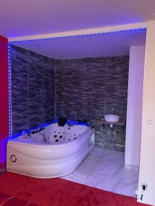 a bathroom with a white tub and a sink at Spa House , love room in Tremblay-En-France