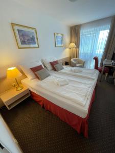 um quarto com uma cama grande num quarto de hotel em Hotel Oáza Praha em Praga