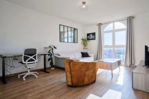 een woonkamer met een bureau en een bank bij Bright apartment in hypercenter with parking in Tourcoing