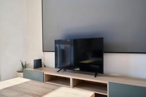 トゥールコワンにあるBright apartment in hypercenter with parkingのエンターテイメントセンターの上に座って薄型テレビを見ることができます。