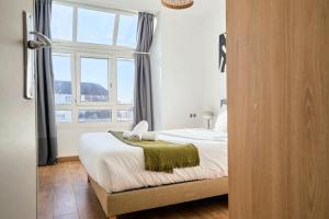 1 dormitorio con cama y ventana en Bright apartment in hypercenter with parking, en Tourcoing