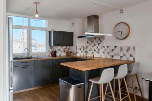 トゥールコワンにあるBright apartment in hypercenter with parkingのキッチン(黒いキャビネット、カウンター、スツール付) +25枚の写真