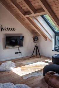 a living room with a vaulted ceiling and a tv at MöhneSeeBlick in Möhnesee