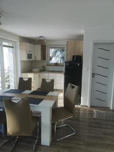 eine Küche mit einem Tisch und Stühlen sowie einem Kühlschrank in der Unterkunft Apartmánový domček Michal in Oravská Lesná