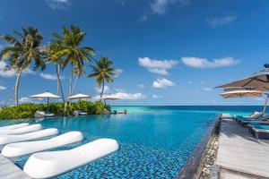 una piscina con tumbonas y el océano en Fushifaru Maldives - 50 percent discount on transfers till 30 Sep 2024 on FB & AI for 04 nights or above en Fushifaru
