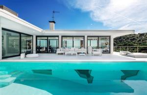 a house with a swimming pool in front of it at Ibiza Style Barcelona in Badalona