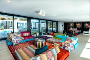 a living room with colorful couches and tables and windows at Ibiza Style Barcelona in Badalona
