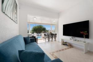 sala de estar con sofá azul y TV en Villa Milena, en Callao Salvaje