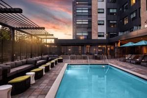 uma piscina de hotel com cadeiras e um edifício em Hyatt House San Jose/Cupertino em Cupertino