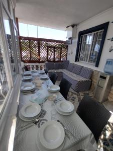 una mesa con platos blancos y cubiertos en Gümüldür sahile 40m DSİ ve TMO kamp yani, aile için uygun, en Gumuldur