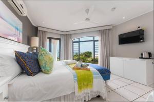 a bedroom with a large bed with a table on it at Lalaria Ocean Villa in Ballito