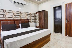 a bedroom with a large bed and a door at OYO Flagship Hotel M. R Galaxy in Kānpur