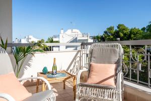 um pátio com cadeiras e uma garrafa de vinho na varanda em Villa del Mar-seaside modern living em Torre a Mare