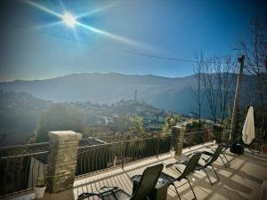 a balcony with chairs and a view of a city at Il Castello Di Venere in Rota d'Imagna