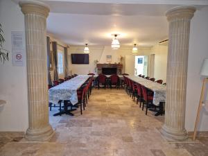 une chambre avec rangées de tables et de chaises avec colonnes dans l'établissement DSN - Domaine Suisse Normande, à Croisilles