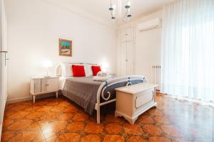 a bedroom with a bed with red pillows and a table at Center Apartament-Housea Travel in Polignano a Mare