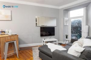 a living room with a couch and a tv at Marvellous 2 bed apartment Edinburgh in Edinburgh