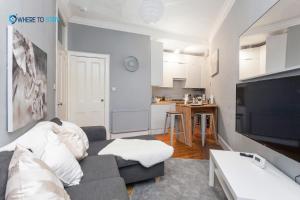 a living room with a couch and a kitchen at Marvellous 2 bed apartment Edinburgh in Edinburgh