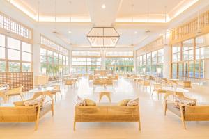 una cafetería con mesas, sillas y ventanas en Glenmarie Hotel and Golf Resort, en Shah Alam