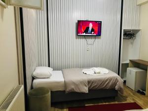 伊斯坦布尔Halil Bey Konağı的一间设有床铺和墙上电视的房间