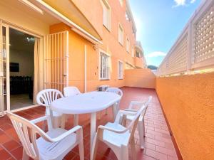 d'une table et de chaises blanches sur un balcon. dans l'établissement Ipanema Costa - Islantilla, à Islantilla