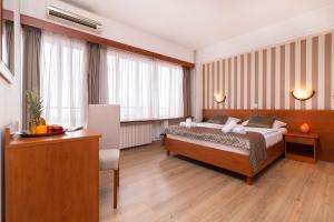 a hotel room with a bed and a desk at Hotel Neboder in Rijeka