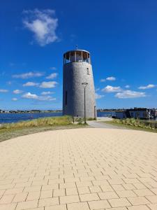 a lighthouse on the shore of a body of water at Fehmarn-OstseeferienHimmelskieker 173 in Burgtiefe auf Fehmarn 