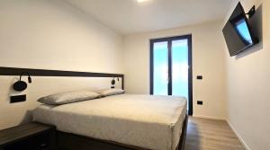 a bedroom with a bed and a television on the wall at ANDALO RELAX APARTMENT in Andalo
