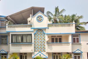 a building with a clock on the side of it at Calangute Cosy 1 bhk Apartment in Calangute