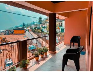 a balcony with chairs and a view of a city at Morning Calm Homestay, Joshimath in Joshīmath