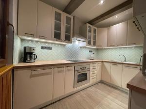 a kitchen with white cabinets and a stove at Chata na Soláni in Vsetín