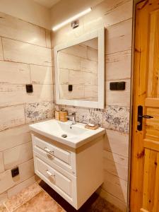 a bathroom with a white sink and a mirror at Chata na Soláni in Vsetín