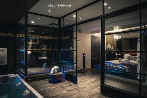 a room with glass walls and a bedroom with a bed at Suite Wellness in Sprimont