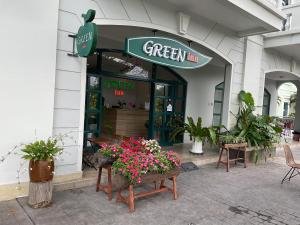 un negozio di locanda verde con fiori nella parte anteriore di Green Inn Phu Quoc Hotel a Phu Quoc
