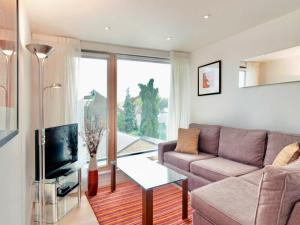 a living room with a couch and a tv at Your Space Apartments - Cambridge Place in Cambridge