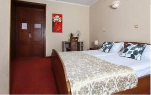 1 dormitorio con 1 cama y puerta de madera en Guesthouse Risnik, en Divača
